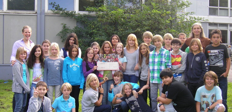 Eine deutsche Schulklasse präsentiert den Scheck für eine Spende. Eine deutsche Schulklasse präsentiert den Scheck für eine Spende.