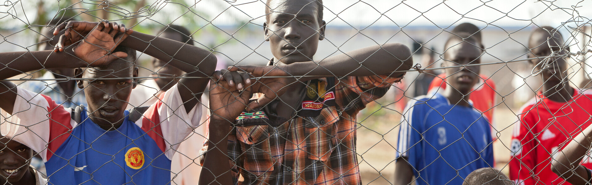 Menschen in Kenia stehen am Zaun eines Flüchtlingscamps