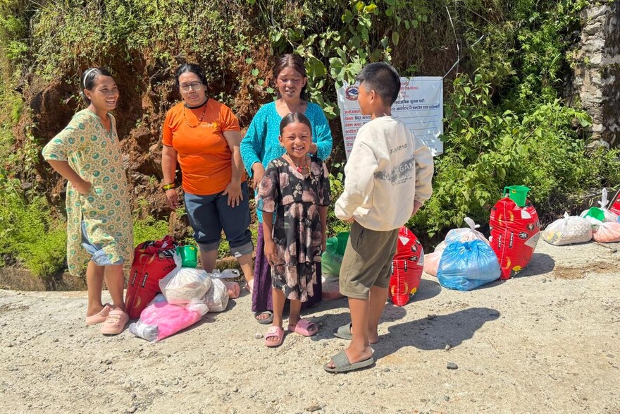 Frauen und Kinder in Nepal haben nach der Flut Nahrungsmittelpakete erhalten