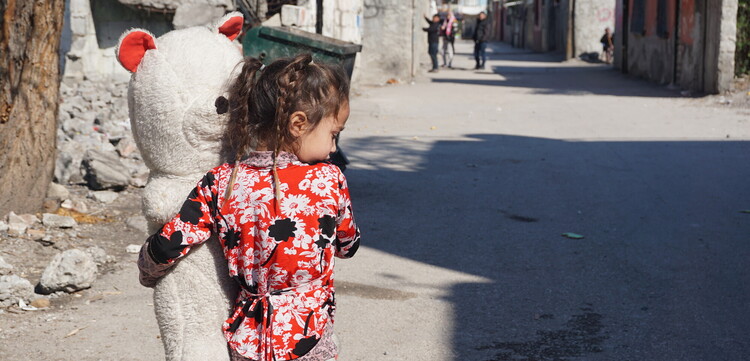 Ein Mädchen trägt nach dem Erdbeben in der Türkei einen großen Teddybär auf dem Arm