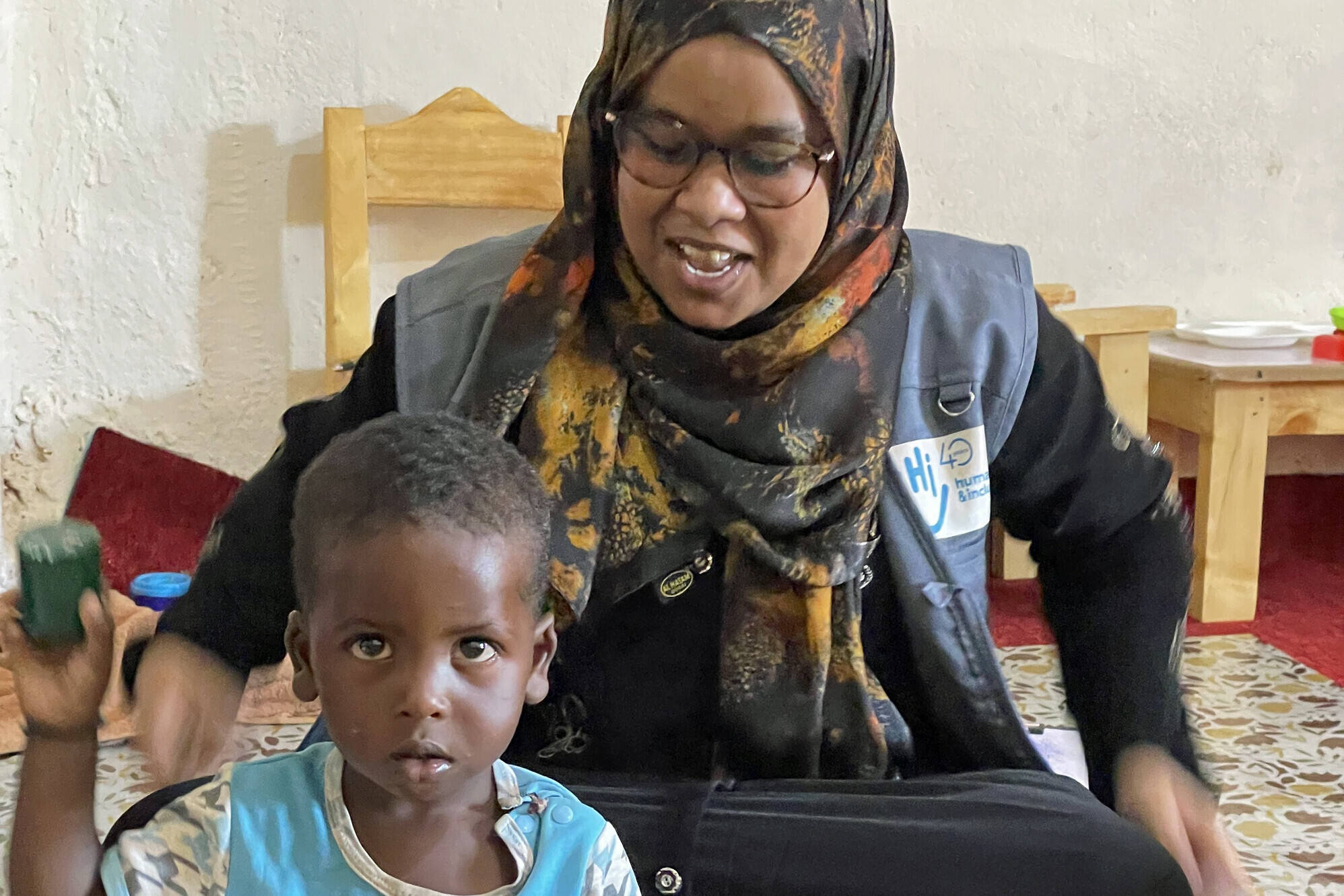 Handicap International fördert in Somalia unterernährte Kinder Eine Helferin von Handicap International spielt mit einem Jungen