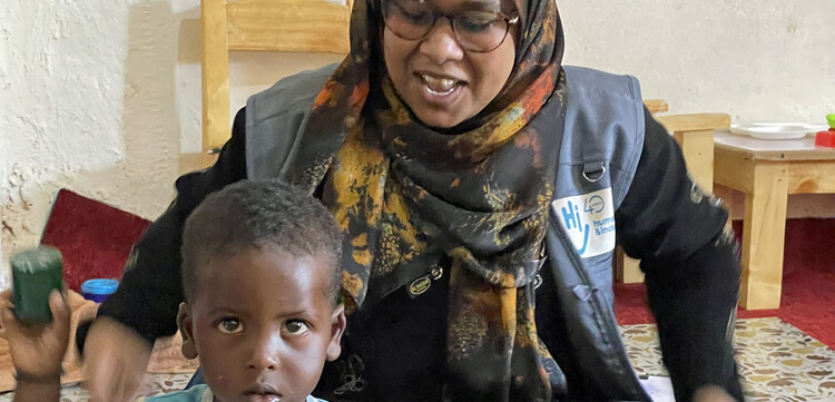 Handicap International fördert in Somalia unterernährte Kinder Eine Helferin von Handicap International spielt mit einem Jungen