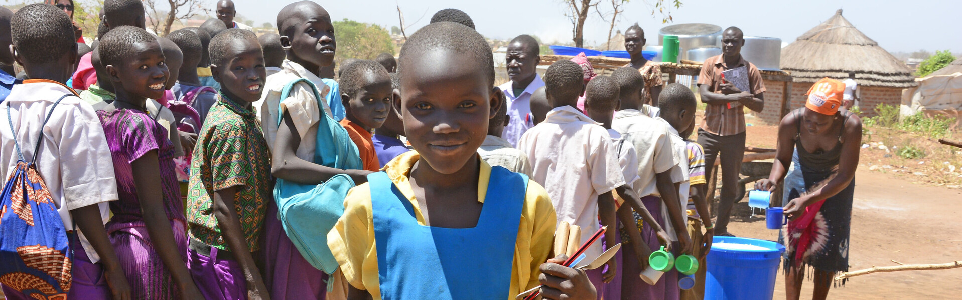 Schulkinder in Uganda erhalten eine Mahlzeit - eines von vielen Hilfsprojekten unseres Bündnisses in Afrika