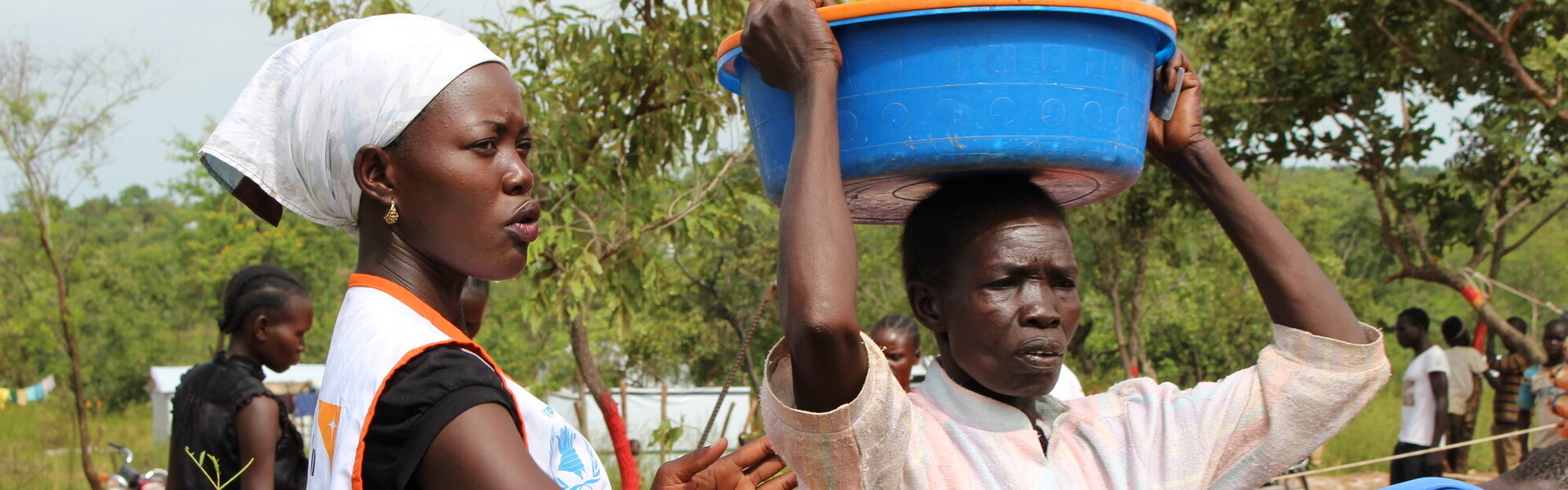 Eine Helferin in Uganda verteilt Nahrungsmittel an Flüchtlinge