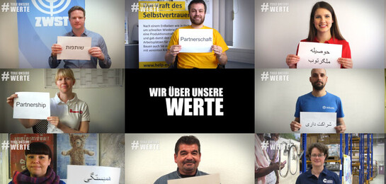 Bündnismitglieder und Helfer von Aktion Deutschland Hilft zeigen Schilder mit verschiedenen Werten darauf.