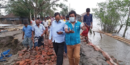 Ein Helfer von der Organisation ADRA verschafft sich in einem Dorf in Bangladesch einen Überblick über die Zerstörung durch den Zyklon Amphan