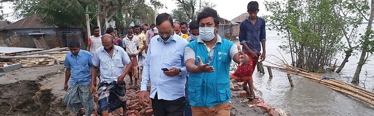 Ein Helfer von der Organisation ADRA verschafft sich in einem Dorf in Bangladesch einen Überblick über die Zerstörung durch den Zyklon Amphan
