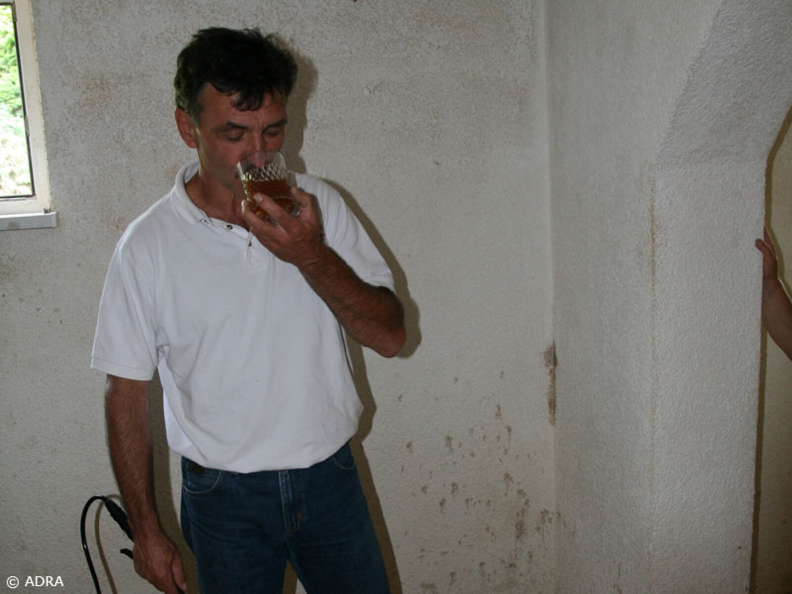 Mann bei der Anwednung der effektiven Mikroorganismen in einem Kellerraum