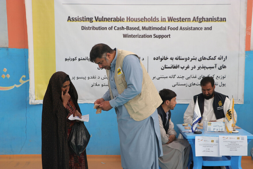 Eine Frau in Afghanistan erhält Bargeld von einem Helfer