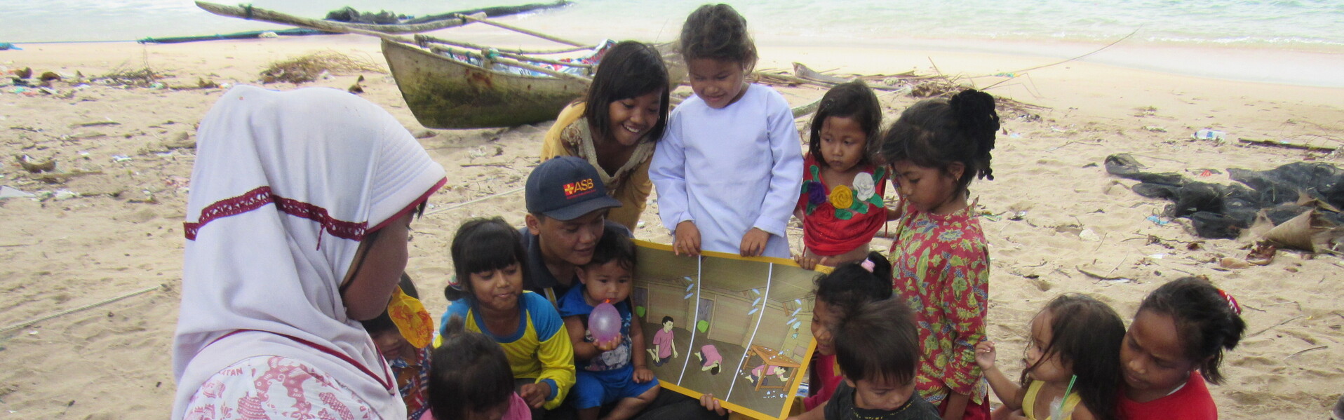 Mädchen und Jungen in Indonesien üben an einem Strand richtiges Verhalten bei Naturkatastrophen