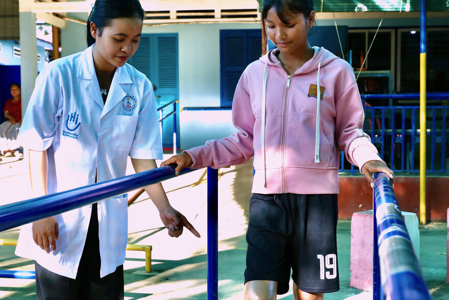 Ein Mädchen aus Kambodscha mit Prothese erhält Physiotherapie von einer Fachkraft