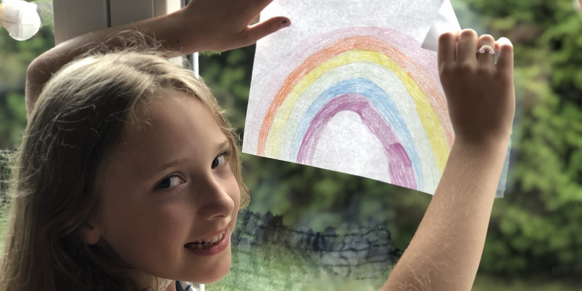 Ein Mädchen hängt während der Corona-Pandemie einen Regenbogen ins Fenster, um anderen Kindern Hoffnung zu schenken Ein Mädchen hängt während der Corona-Pandemie einen Regenbogen ins Fenster, um anderen Kindern Hoffnung zu schenken