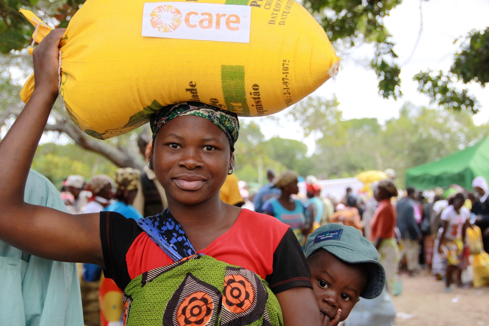Ein Frau mit Kind erhält Nahrungsmittel in Simbabwe während der Dürre- und Hungerkatastrophe durch die Auswirkungen von El Niño.