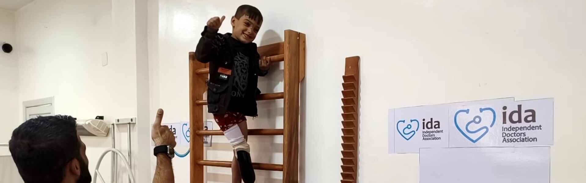 Ein Junge und ein Helfer bei einer physiotherapeutischen Behandlung