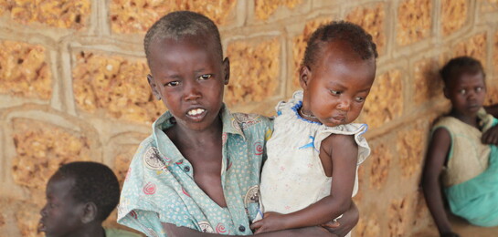 Ein Junge hält seine jüngere Schwester auf dem Arm im Südsudan.