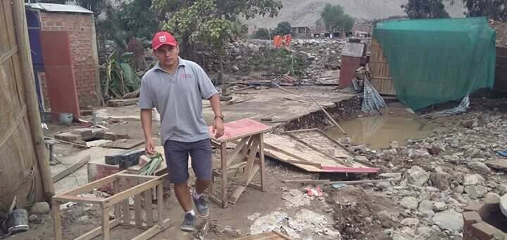 In Peru läuft ein Mann durch ein von Regen und Überschwemmungen zerstörtes Dorf.