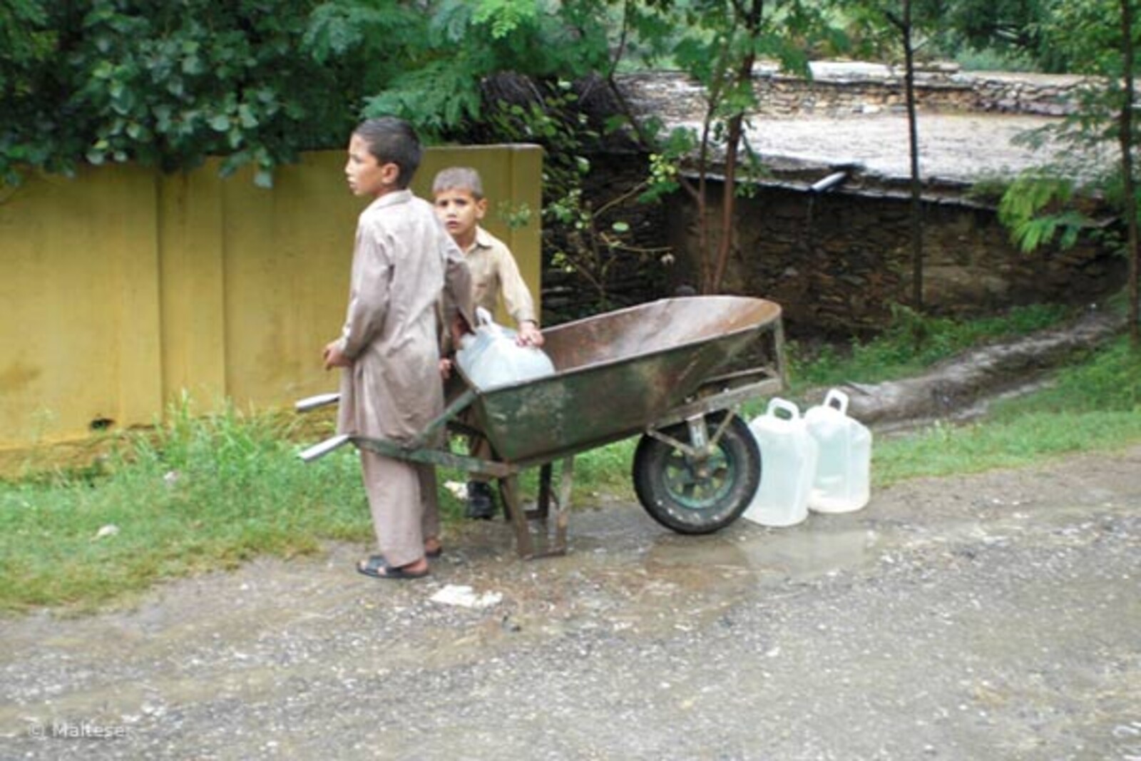 schubkarre Flut Pakistan: Jungen holen mit einer Schukarre Wasserkanister