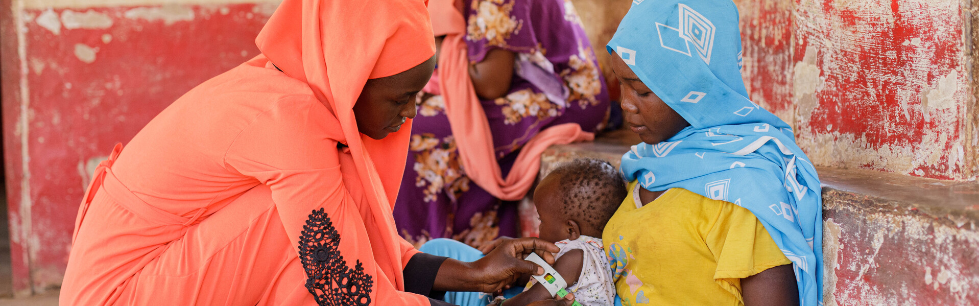 Zwei Frauen im Südsudan messen den Umfang eines Arms bei einem Kind Zwei Frauen im Südsudan messen den Umfang eines Arms bei einem Kind