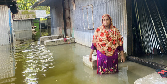 Eine Frau in Bangladesch steht im knietiefen Wasser