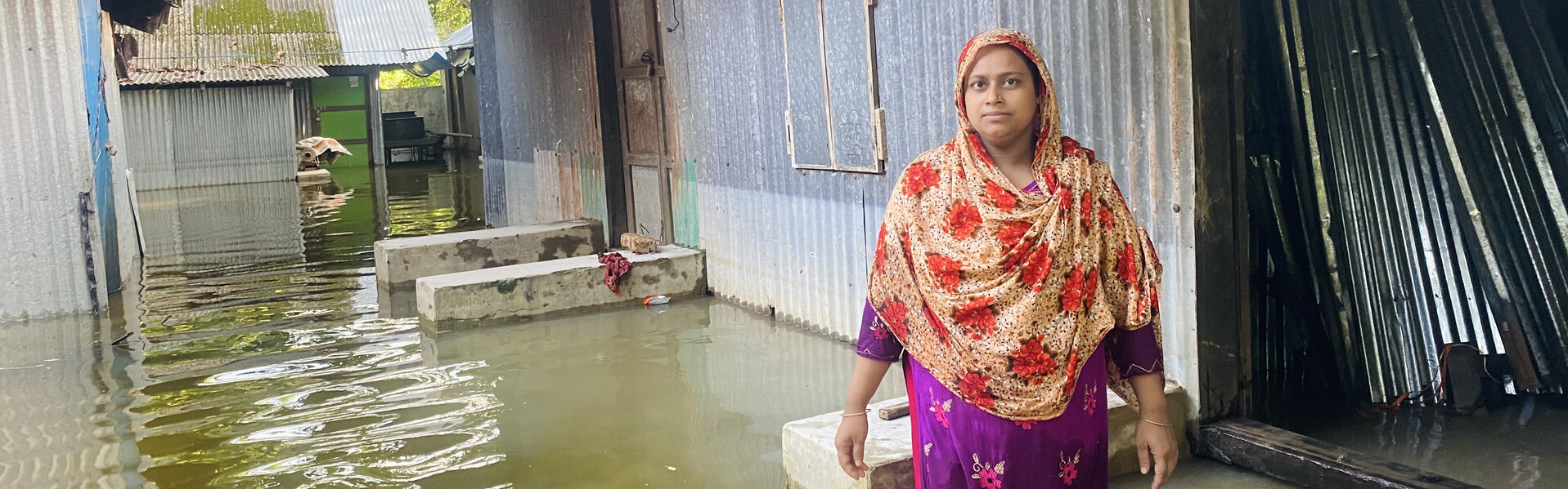 Eine Frau in Bangladesch steht im knietiefen Wasser