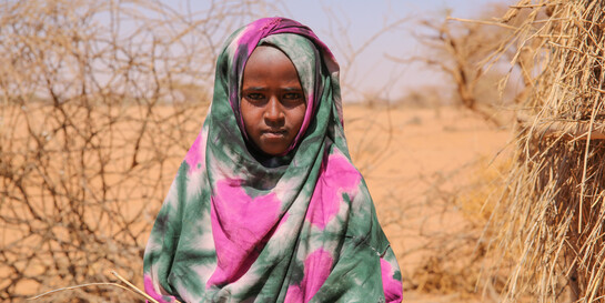 Kind in Somalia hält trockenes Stroh in den Händen.