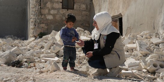 Helferin mit Kind im Erdbebengebiet Türkei/Syrien