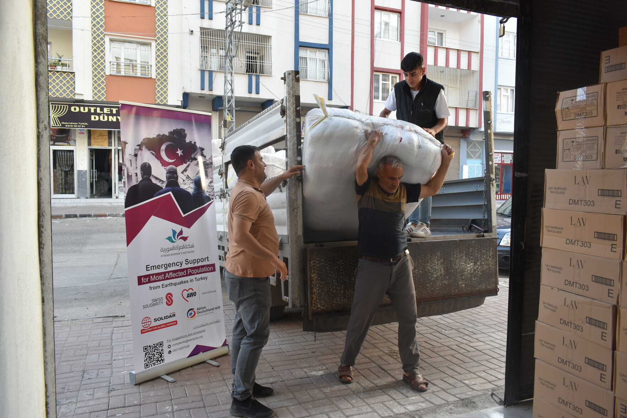 Männer verteilen Hilfsgüter in Erdbebengebiet Türkei/Syrien Männer verteilen Hilfsgüter in Erdbebengebiet Türkei/Syrien