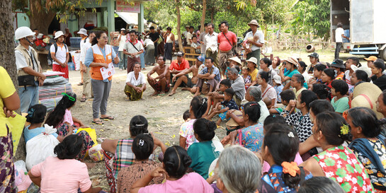 Eine Helferin von World Vision spricht vor einer Menschengruppe in Myanmar