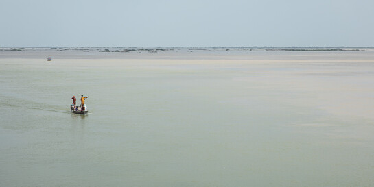 Menschen in einem Boot auf dem überschwemmten Fluss Indus in Pakistan im Jahr 2022