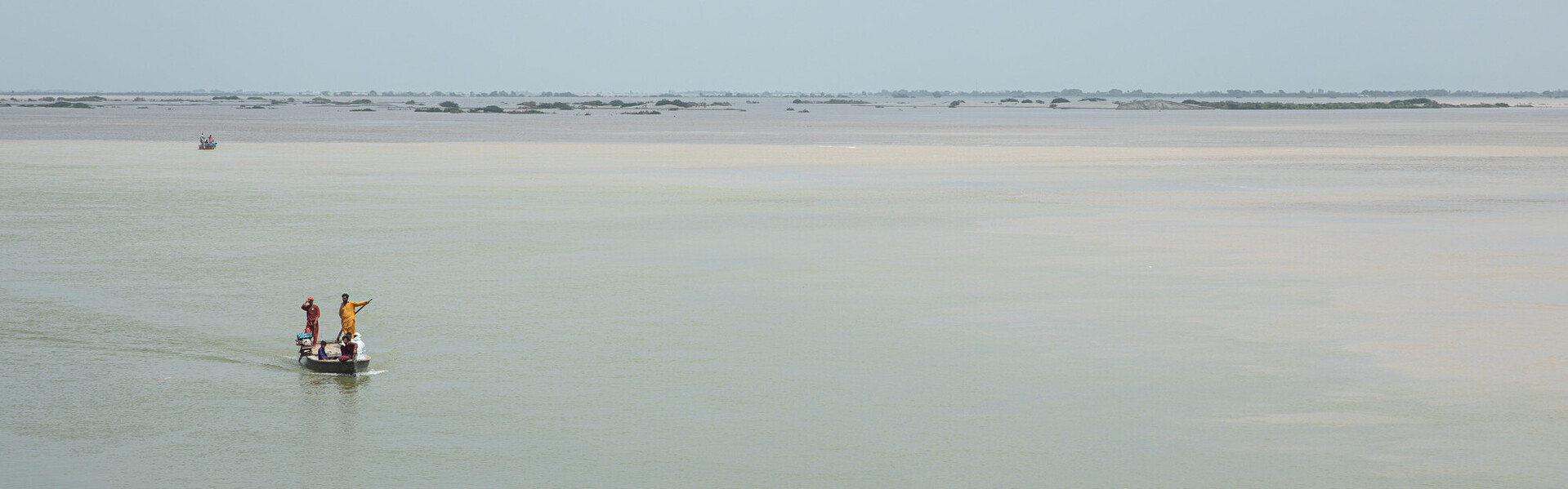 Menschen in einem Boot auf dem überschwemmten Fluss Indus in Pakistan im Jahr 2022