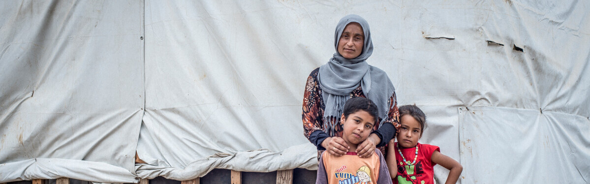 Eine aus Syrien geflüchtete Familie steht vor ihrer Notunterkunft 