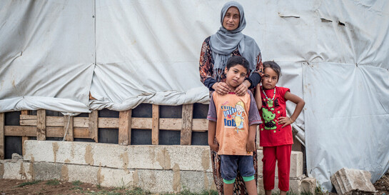 Eine aus Syrien geflüchtete Familie steht vor ihrer Notunterkunft 
