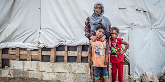 Eine aus Syrien geflüchtete Familie steht vor ihrer Notunterkunft 