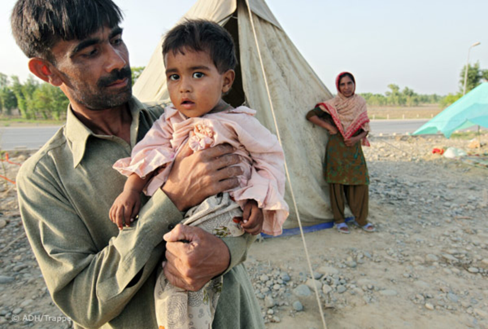 Flut Pakistan:27.08.2010, Pakistan, Nowshera - Hochwasser Pakistan. Auf der Autobahnstrecke Richtung Peshawar campieren Flüchtlinge des Hochwassers in Zelten.