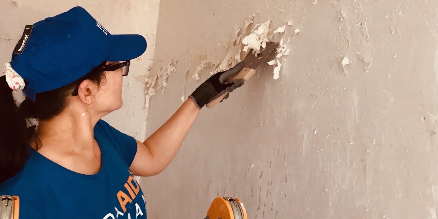 Eine Helferin unterstützt bei der Entkernung eines überschwemmten Hauses