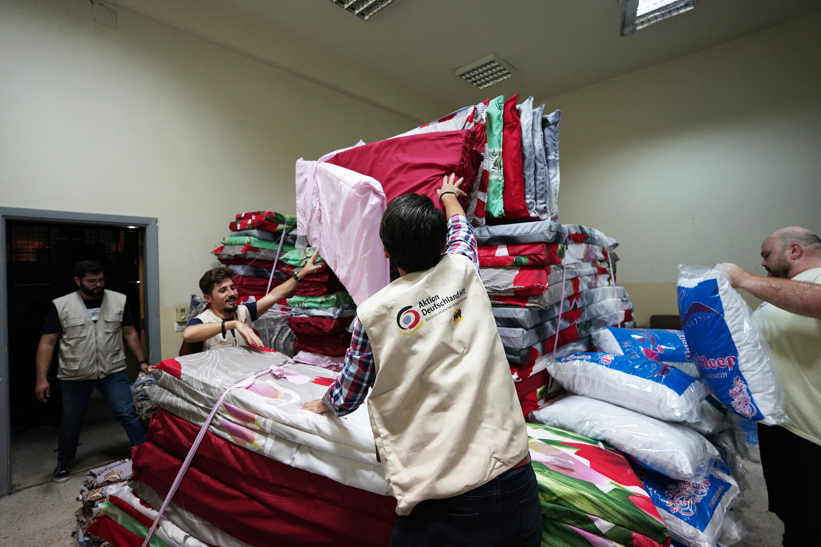 Helfer einer lokalen Partnerorganisation von Help verteilen Matratzen im Libanon