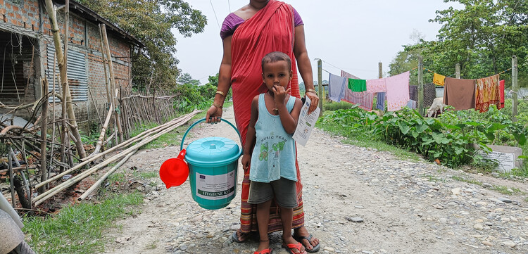 Eine Frau mit ihrem Kind hält ein Hygienekit in der Hand Eine Frau mit ihrem Kind hält ein Hygienekit in der Hand