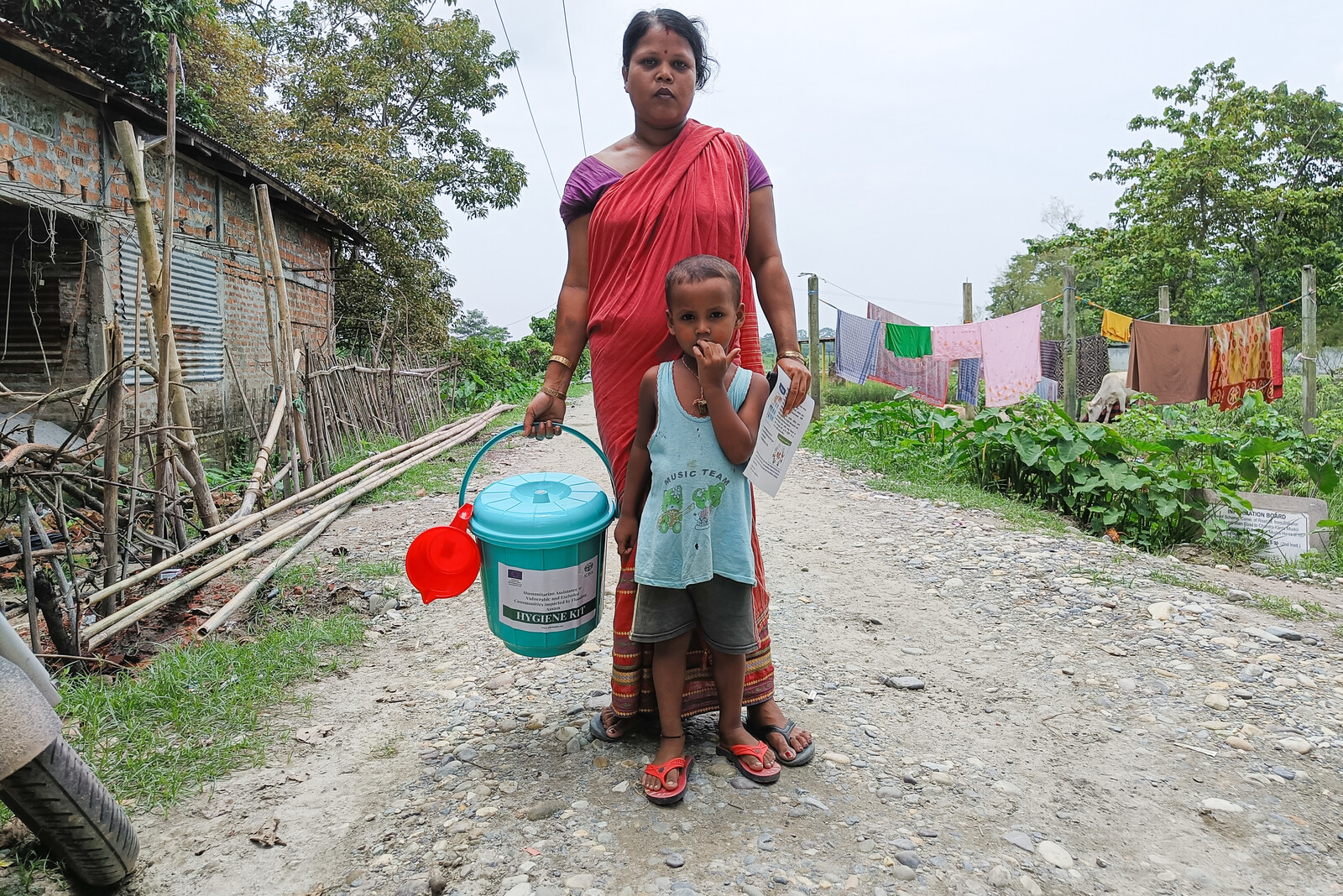 Eine Frau mit ihrem Kind hält ein Hygienekit in der Hand