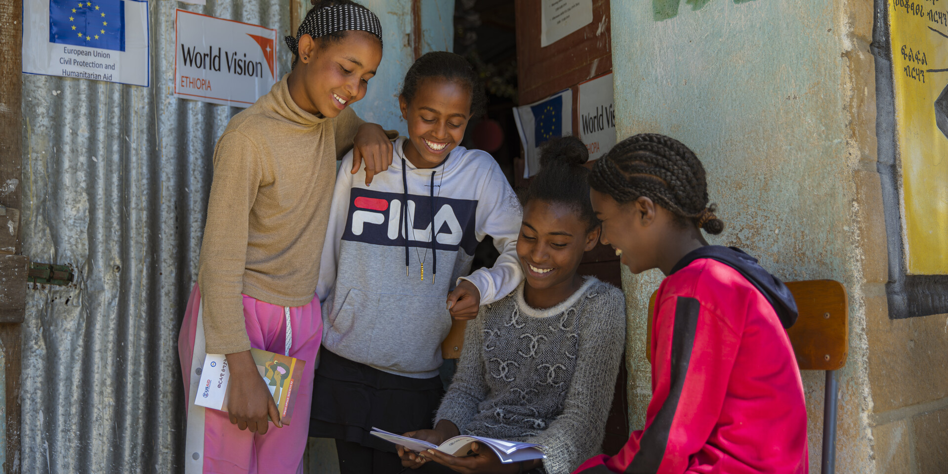Vier Mädchen schauen gemeinsam auf eine Broschüre