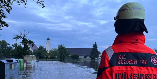 Ein Helfer der Johanniter steht im Juni 2024 im Flutgebiet in Bayern – dort hatte es Mitte des Jahres vielerorts schon starke Überschwemmungen gegeben, Symbolbild
