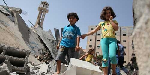 Children run through a field of rubble