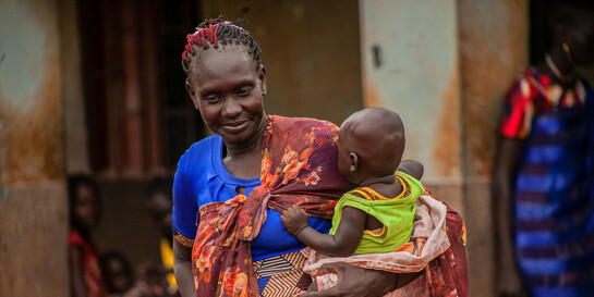 Eine Mutter aus dem Südsudan hält ihr Kind im Arm