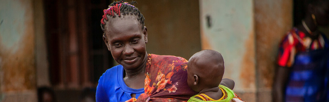 Eine Mutter aus dem Südsudan hält ihr Kind im Arm