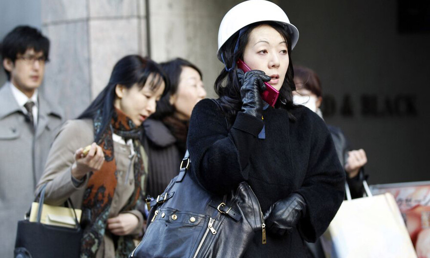 frau-telefon In Tokios Finanzdistrikt telefoniert eine Frau, nachdem sie aus dem Gebäude evakuiert wurde. © REUTERS/KYODO Kyodo