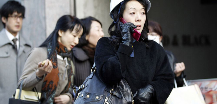 In Tokios Finanzdistrikt telefoniert eine Frau, nachdem sie aus dem Gebäude evakuiert wurde. © REUTERS/KYODO Kyodo