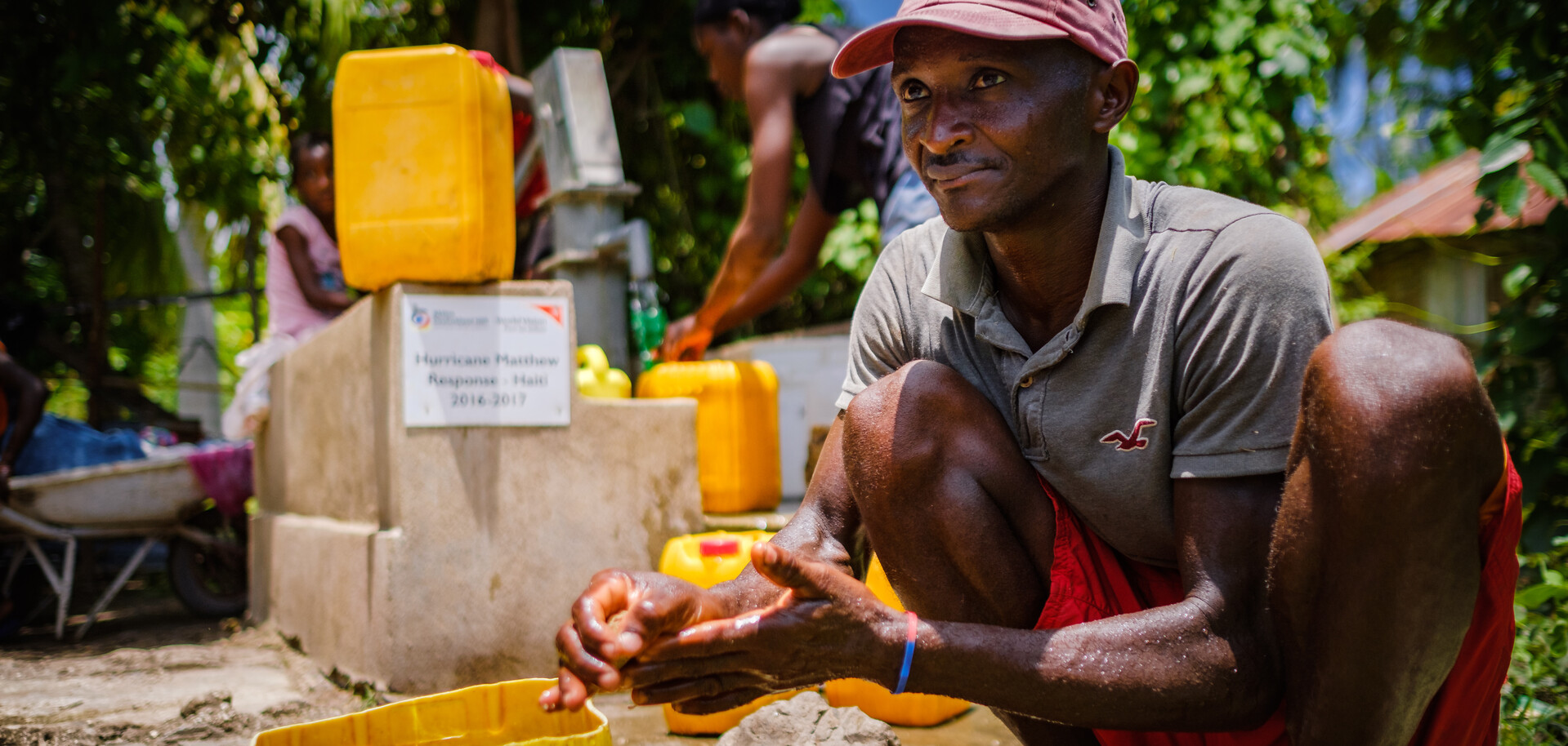 Ein Mann wäscht sich an einem Wasserbrunnen die Hände in Haiti. Ein Mann wäscht sich an einem Wasserbrunnen die Hände in Haiti.