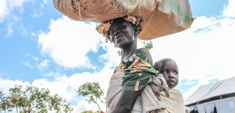 Frau mit Kind in Uganda, wo Hilfsorganisation Nahrungsmittel an Menschen verteilt hat, die von Hunger betroffen sind Frau mit Kind in Uganda, wo Hilfsorganisation Nahrungsmittel an Menschen verteilt hat, die von Hunger betroffen sind