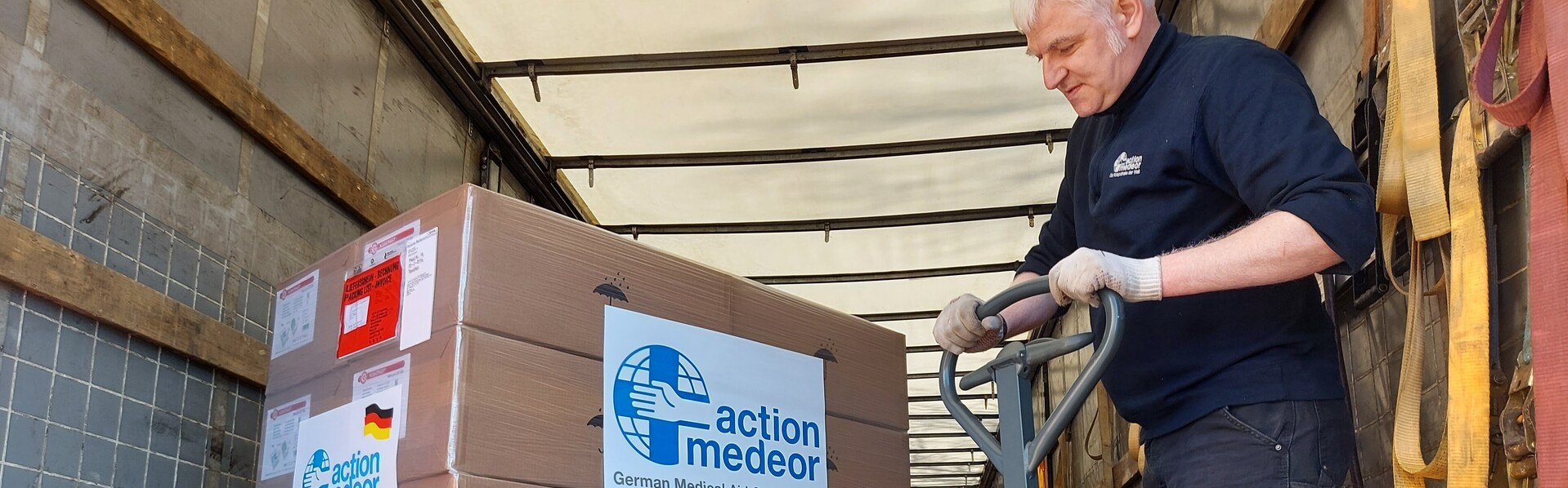 Ein Helfer der Bündnisorganisation action medeor verstaut Hilfspakete für die Ukraine in einem Transporter