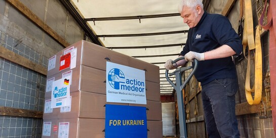 Ein Helfer der Bündnisorganisation action medeor verstaut Hilfspakete für die Ukraine in einem Transporter