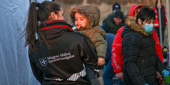 Eine Helferin der Malteser International versorgt geflüchtete Frauen und Kinder aus der Ukraine